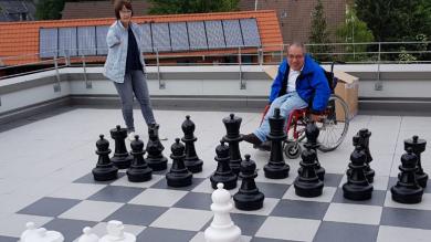 Benedikt und Michael beim Schachspiel mit den großen Gartenschachfiguren